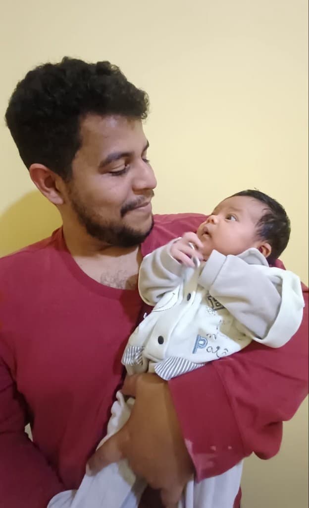 João Carlos com a filha no colo, trocando olhares